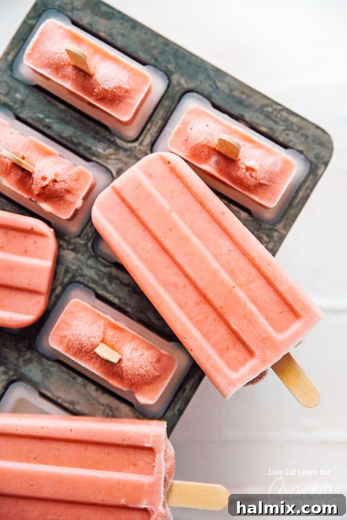Strawberry Banana Popsicles in popsicle mold, ready to be frozen. A refreshing and healthy summer treat.