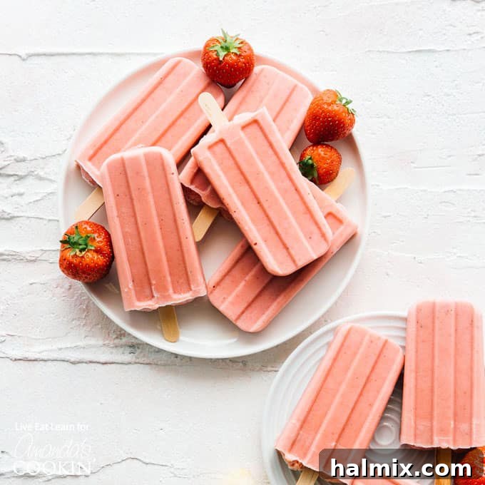 Close-up of strawberry banana popsicles on a plate, showcasing their vibrant color and creamy texture.