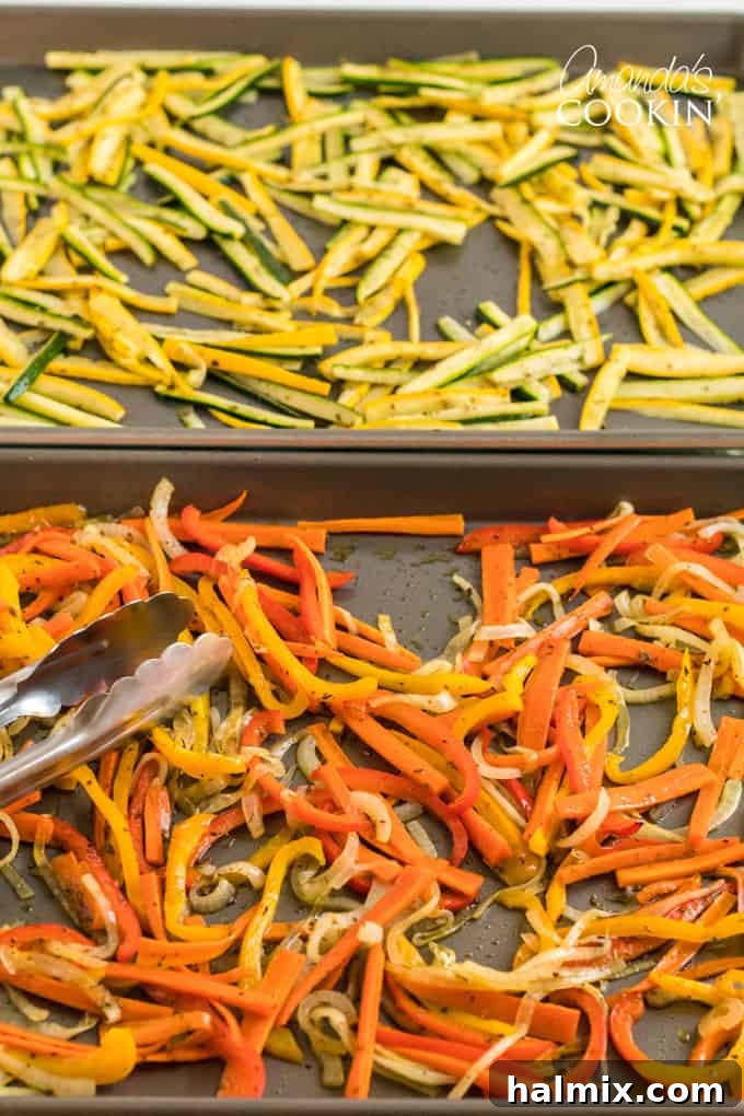Tongs gently lifting roasted vegetables from a hot baking pan, showcasing their golden-brown edges and tender texture.