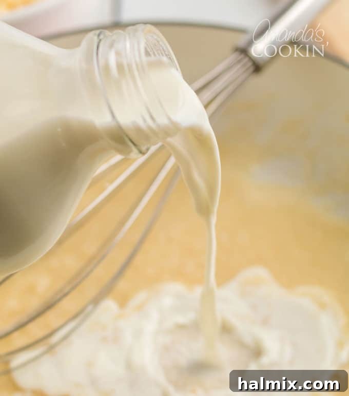 milk bottle pouring into skillet with roux, illustrating the gradual addition of liquid