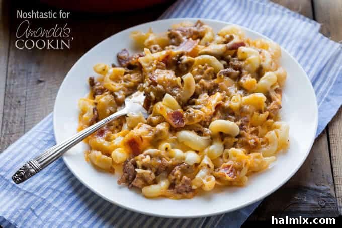 A plate piled high with homemade bacon cheeseburger pasta, showcasing ground beef, bacon, and a cheesy sauce.