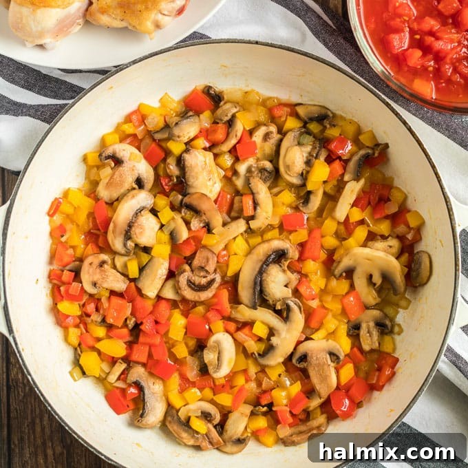 Sauteed bell pepper, onions, and mushrooms for Chicken Cacciatore. Colorful bell peppers, onions, and sliced mushrooms sautéing in the pan, forming the aromatic base for Chicken Cacciatore.