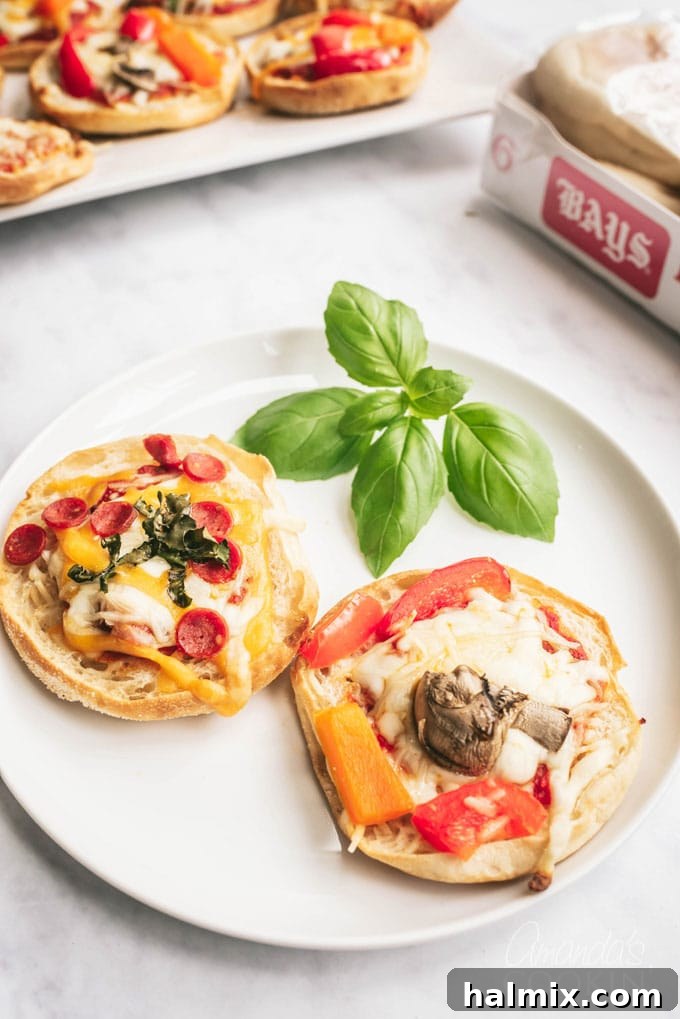 Two perfectly baked English muffin pizzas on a rustic plate, ready to be enjoyed