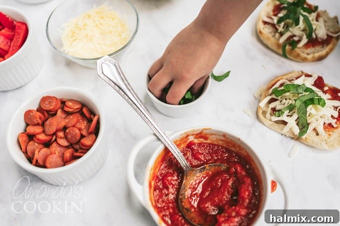 A small child's hand delicately taking a fresh basil leaf from a bowl of toppings for their pizza