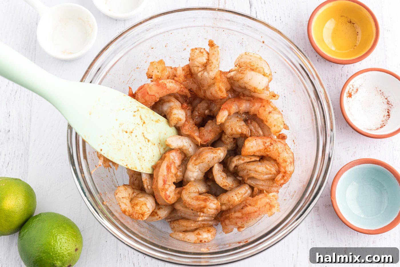 Coastal Shrimp Tacos 5 seasoned raw shrimp in a bowl with a rubber spatula