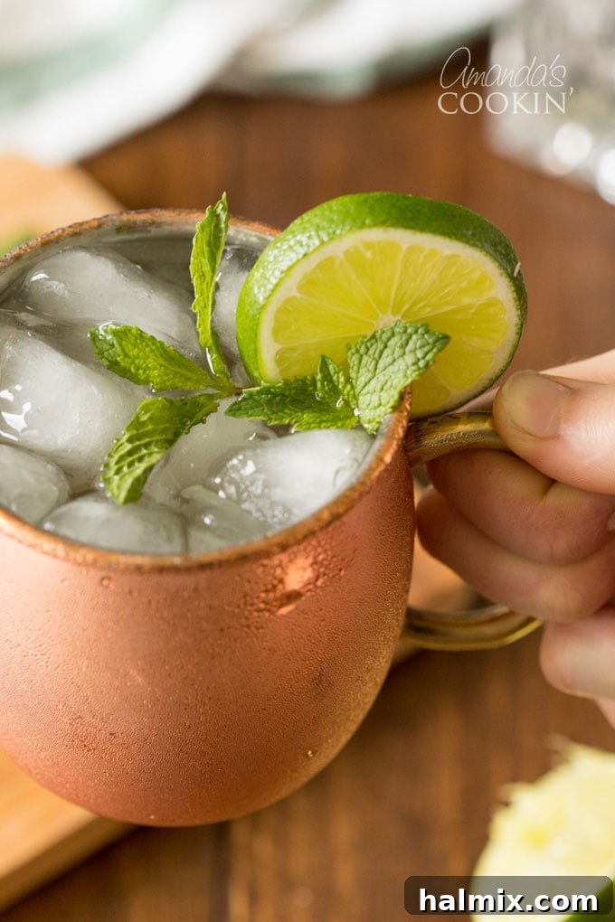 hand holding a copper mug of moscow mule