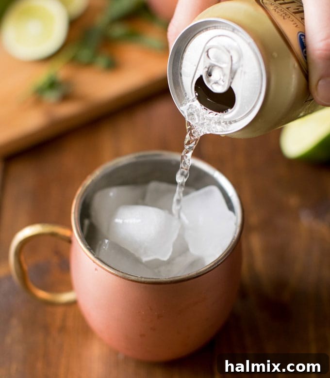 pouring ginger beer into copper mug