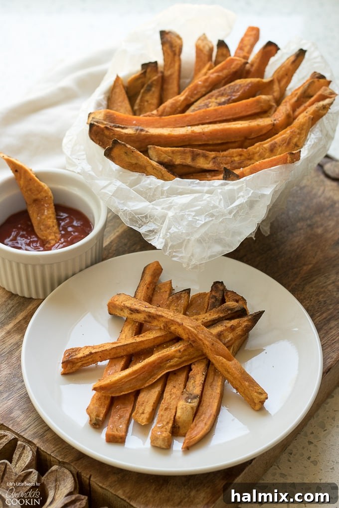 Oven-baked Sweet Potato Fries with a sprinkle of herbs, perfectly golden brown and stacked on a rustic wooden board, ready to be served as a healthy side dish.