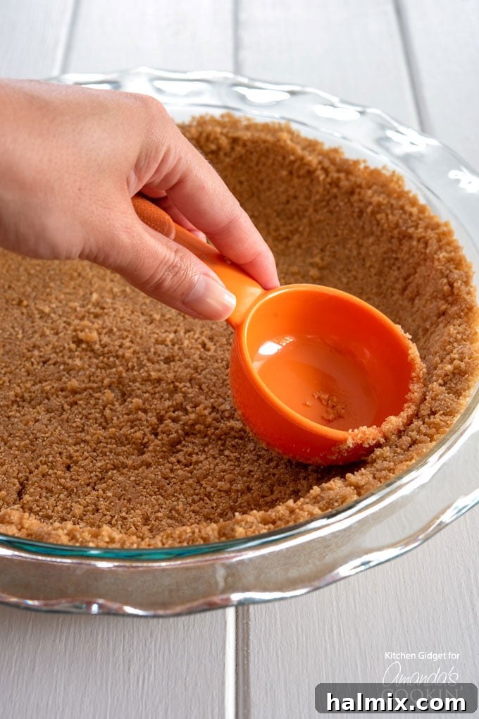pressing down the graham cracker crust