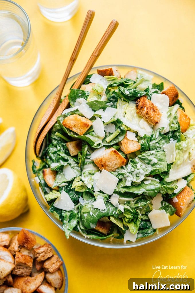A beautifully presented bowl of classic Caesar salad with crisp romaine, golden croutons, and shaved Parmesan