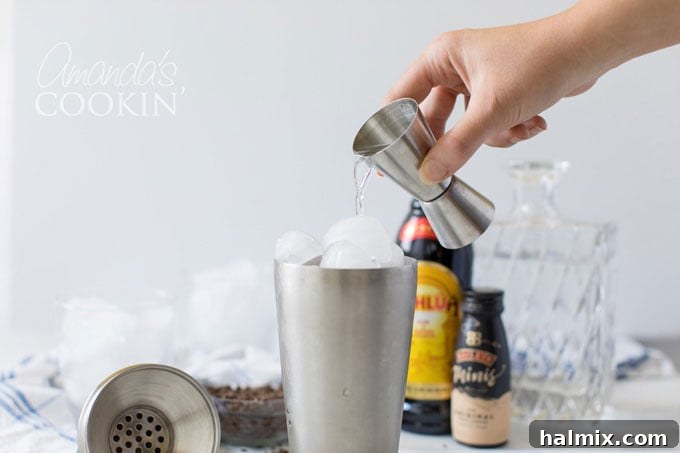 Flowing Devastation 4 Pouring vodka into a cocktail shaker with ice for a Mudslide cocktail