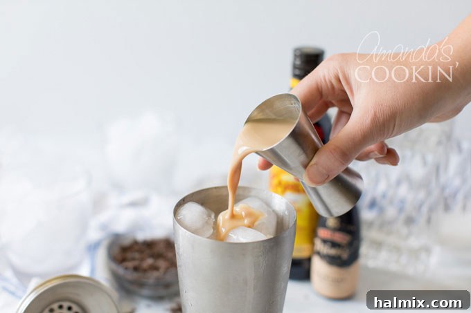 Flowing Devastation 5 Adding Irish cream liqueur to a cocktail shaker for a Mudslide recipe