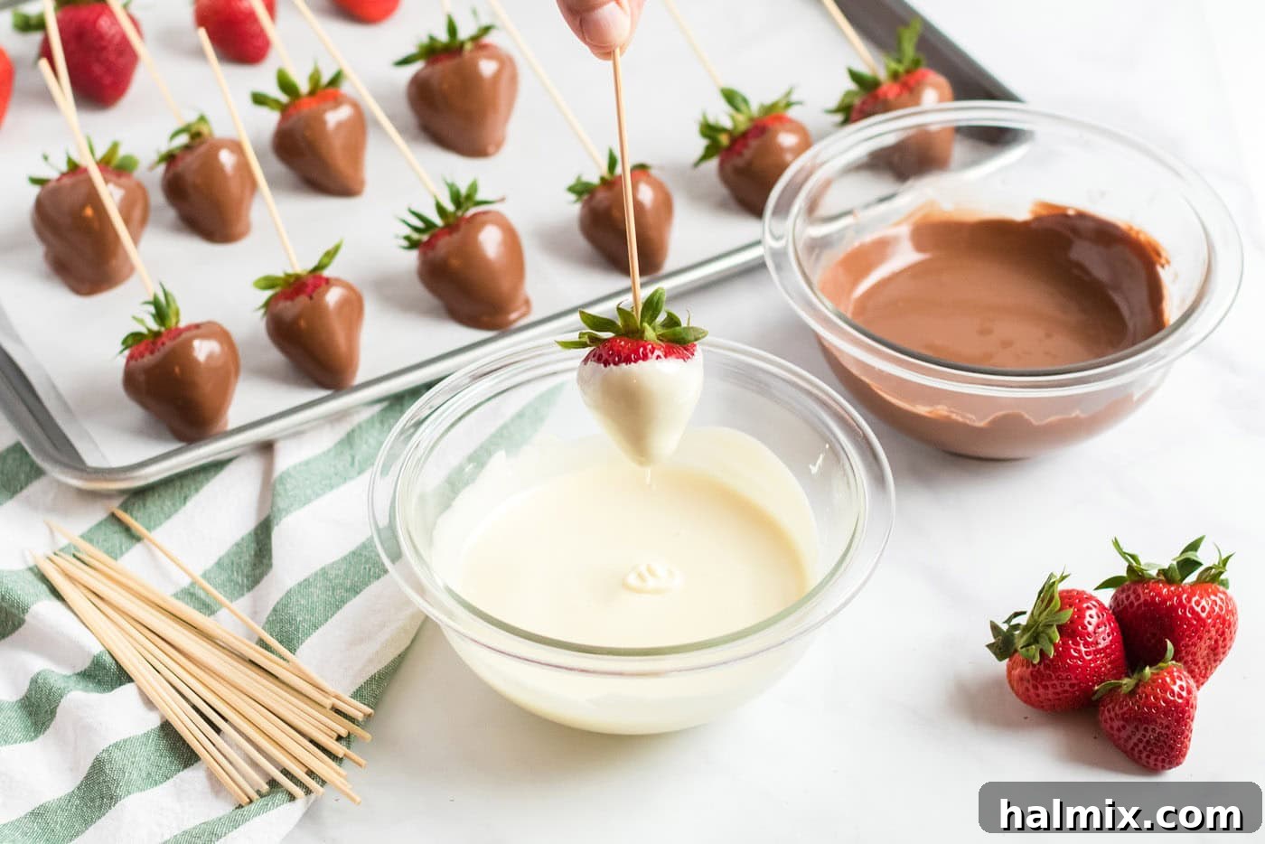 dipping a strawberry into melted chocolate