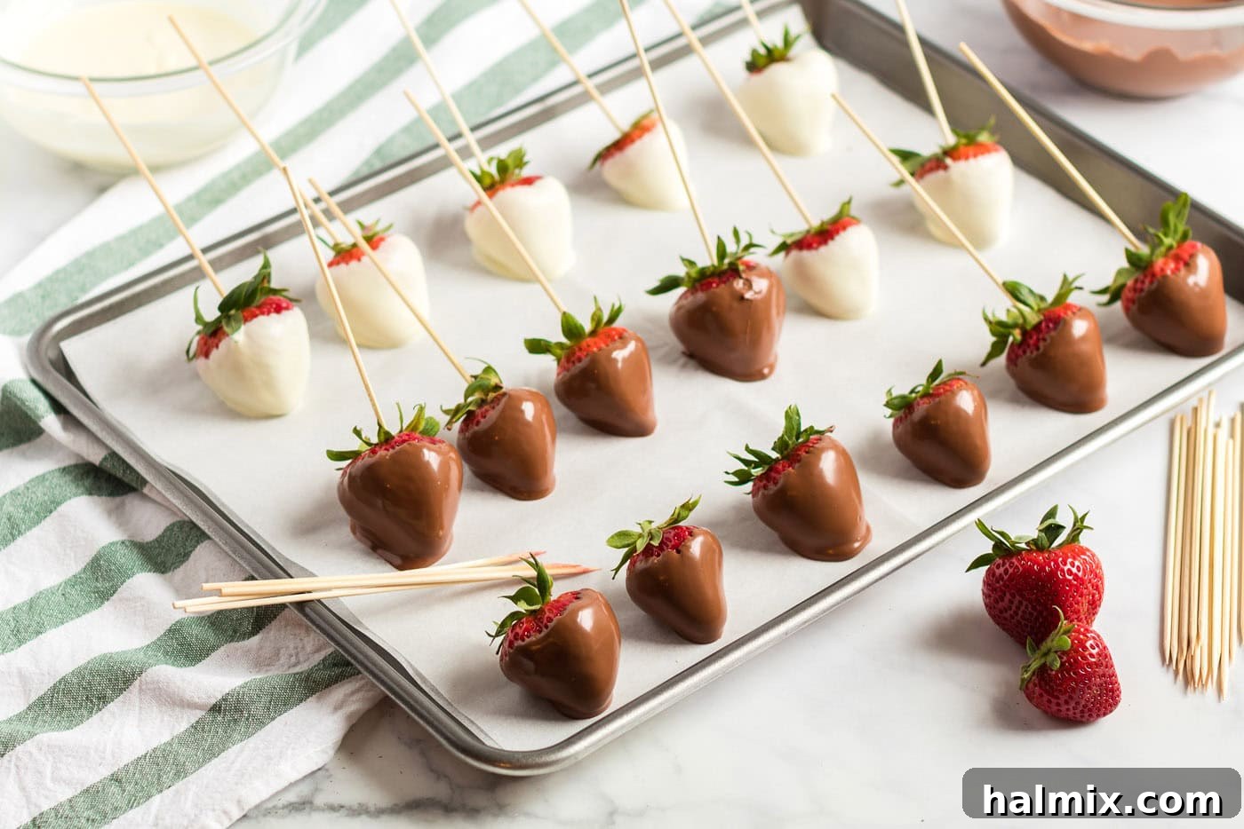 dipped strawberries lined up on a pan