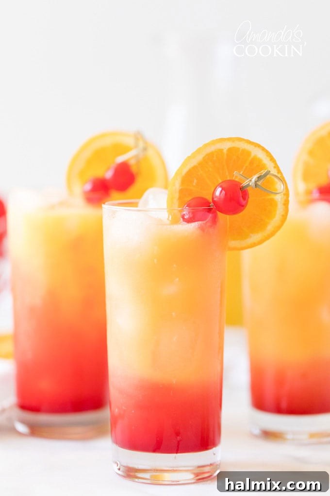 Three glasses of Tequila Sunrise drinks, showing the vibrant gradient of red and orange.