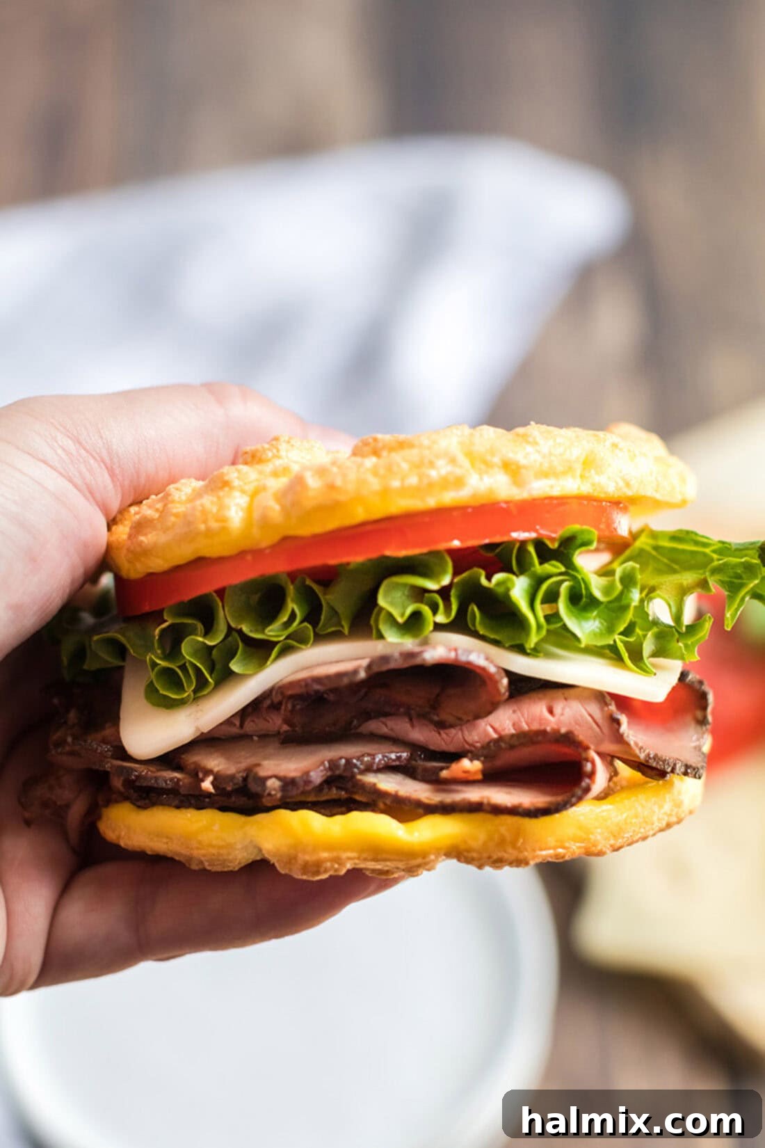 Pillowy Cloud Bread 10 A hand holding a delicious sandwich made with homemade cloud bread, showcasing its versatility