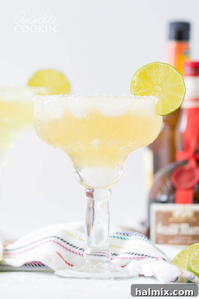 A refreshing Margarita on the rocks, garnished with a vibrant lime wheel, embodying the spirit of celebration. Freshly made Margarita on the rocks with a lime slice garnish, ready to be enjoyed