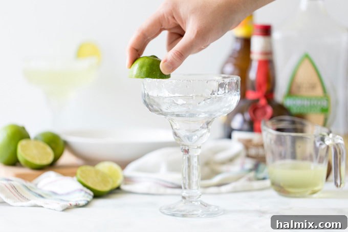 Margarita Magic 3 Rubbing a lime wedge around the rim of a cocktail glass to prepare for salting