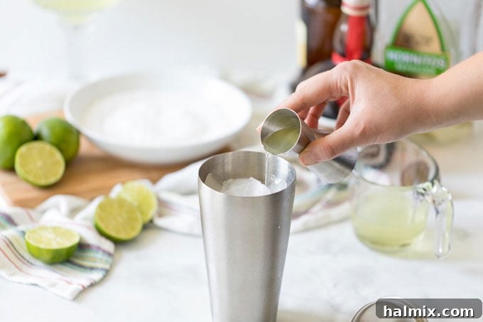 Margarita Magic 6 Pouring tequila into a cocktail shaker, preparing to mix a homemade Margarita