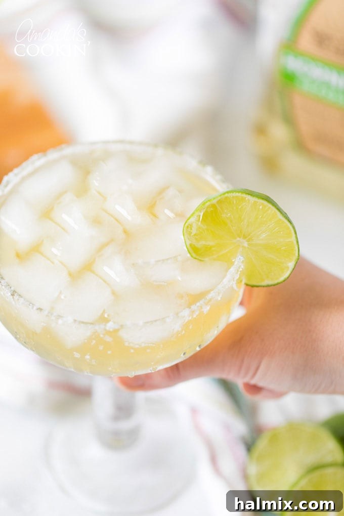 Margarita Magic 7 A hand holding a beautifully garnished Margarita on the rocks, ready to be enjoyed