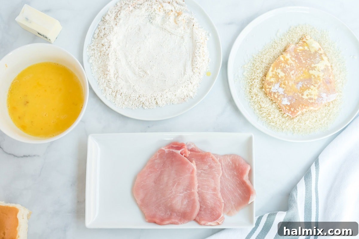 A boneless pork chop coated in a mixture of flour and spices, ready for the next step of breading.