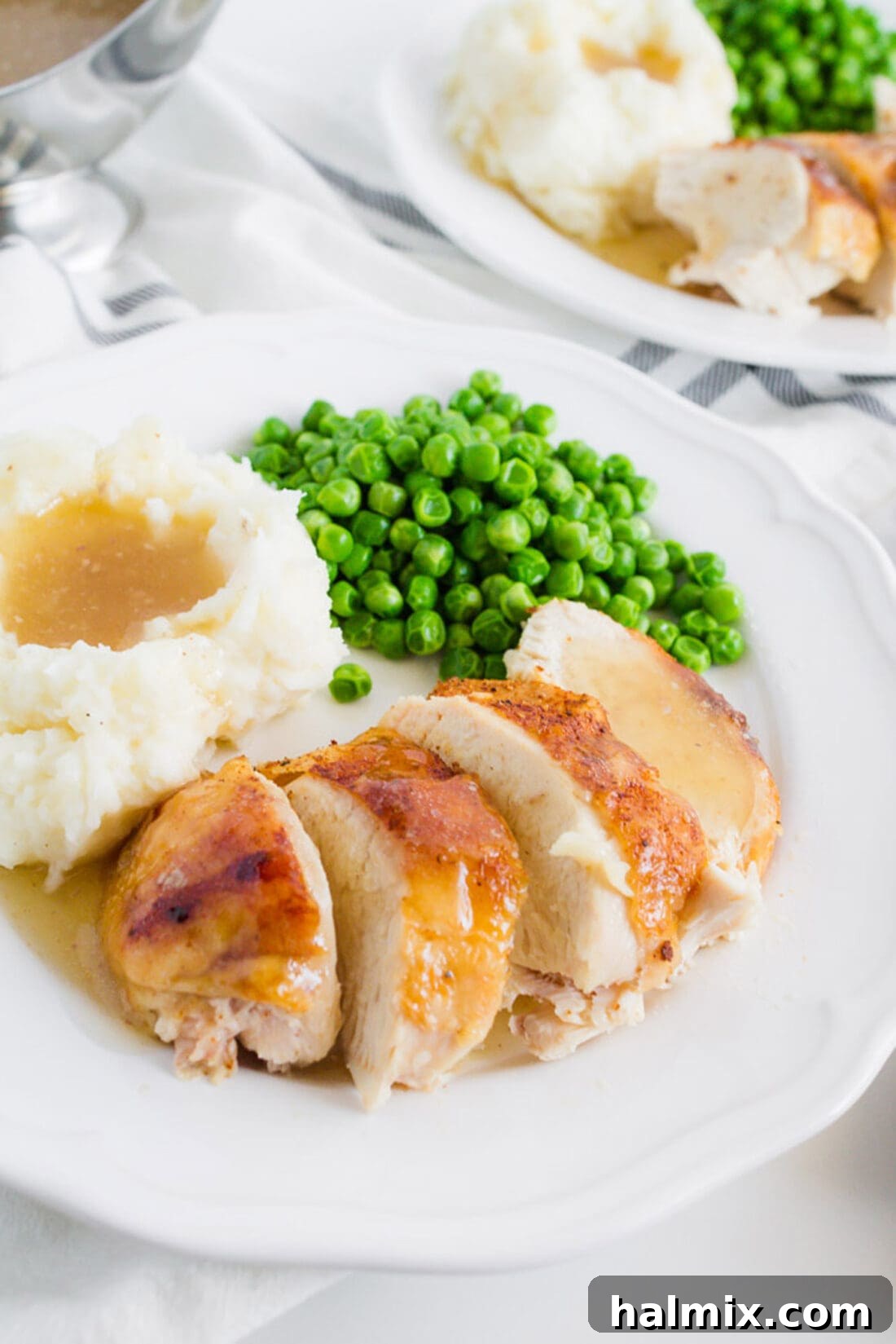 Crockpot Sticky Chicken served on a plate with peas and mashed potatoes, highlighting the rich, glistening sauce and tender chicken.
