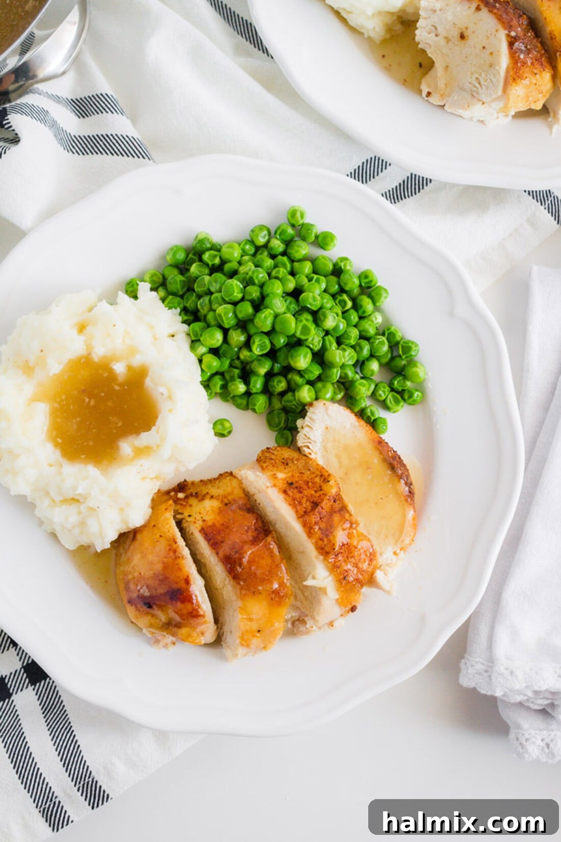 Overhead shot of a single plate featuring Crockpot Sticky Chicken, served alongside fluffy mashed potatoes and vibrant green peas, ready to enjoy.