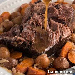 gracy pouring on crockpot roast beef on a platter