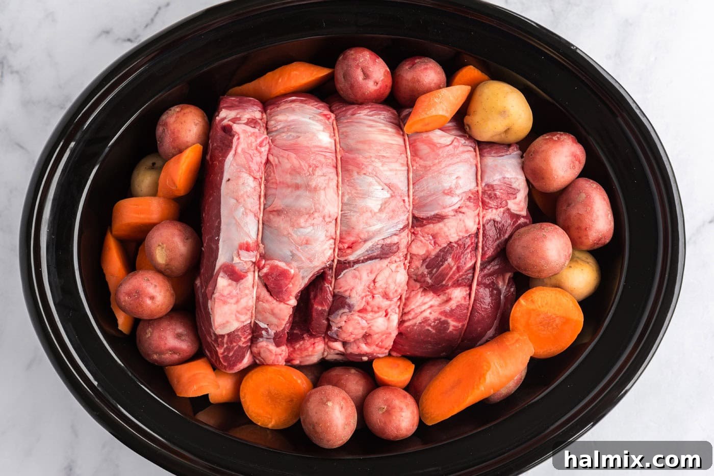 Perfect Slow Cooker Pot Roast 7 beef roast in crockpot surrounded by carrots and potatoes