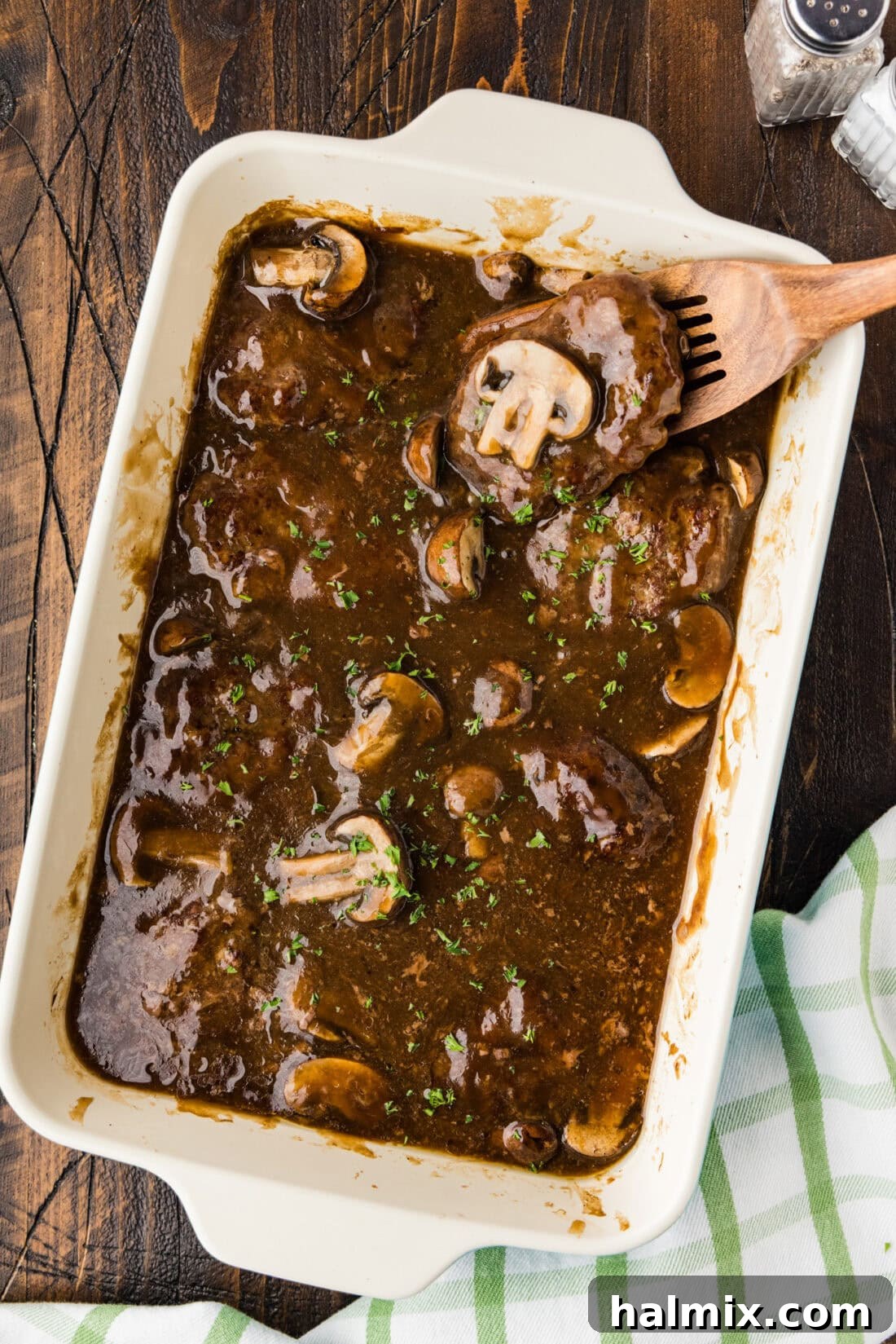 Hearty Salisbury Steaks 3 Baking dish of Salisbury Steaks covered in gravy with a spatula in it, ready to be served.