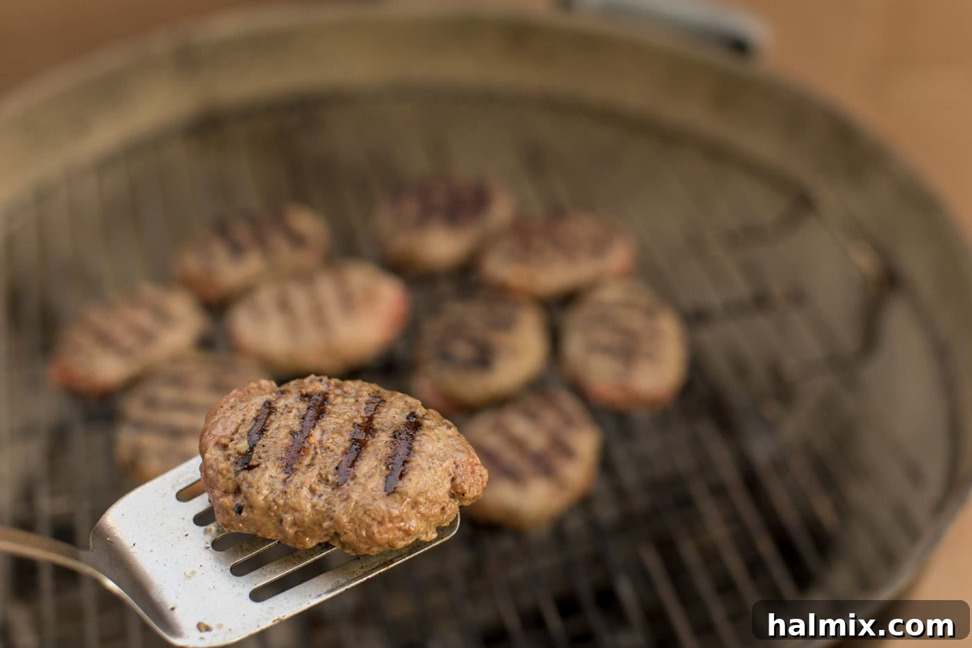 Hearty Salisbury Steaks 7 A spatula lifting a Salisbury steak patty with perfect grill marks, showing the successful searing process.