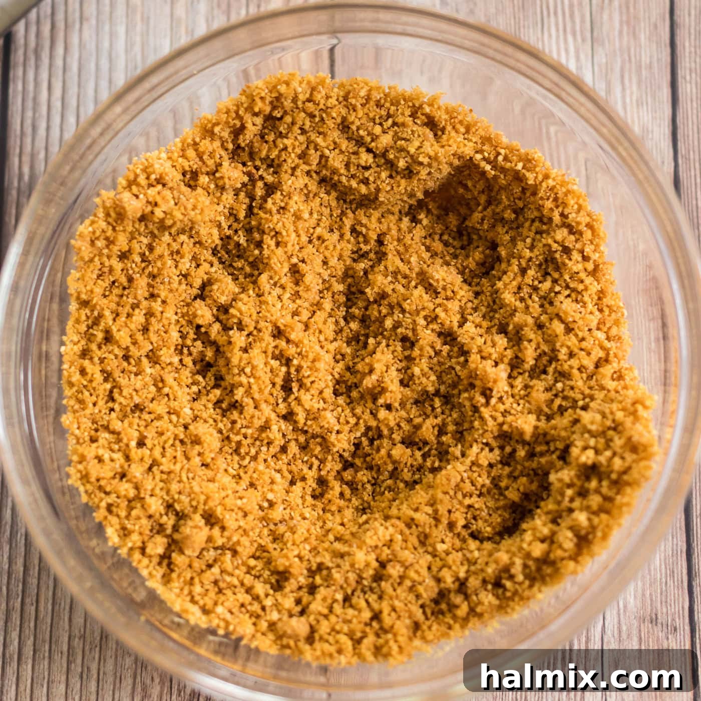 Close-up image of the graham cracker crust mixture in a bowl, showing its crumbly texture