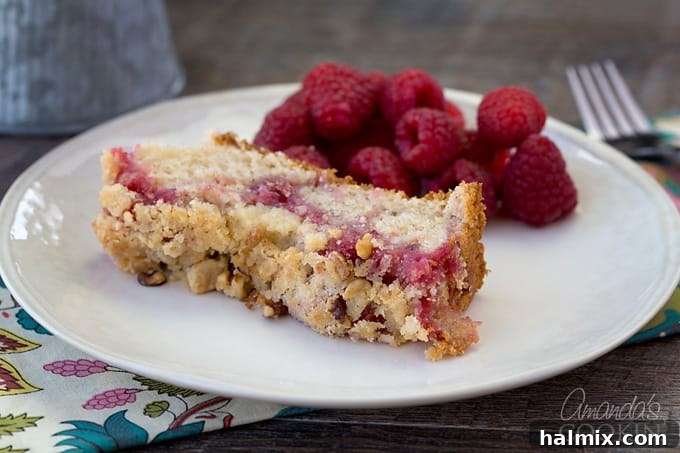 A close-up shot of a slice of scrumptious raspberry coffee cake on a plate, showcasing the vibrant berry swirl and streusel topping.
