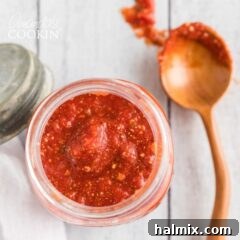 overhead view of jar of pizza sauce with spoon on the side