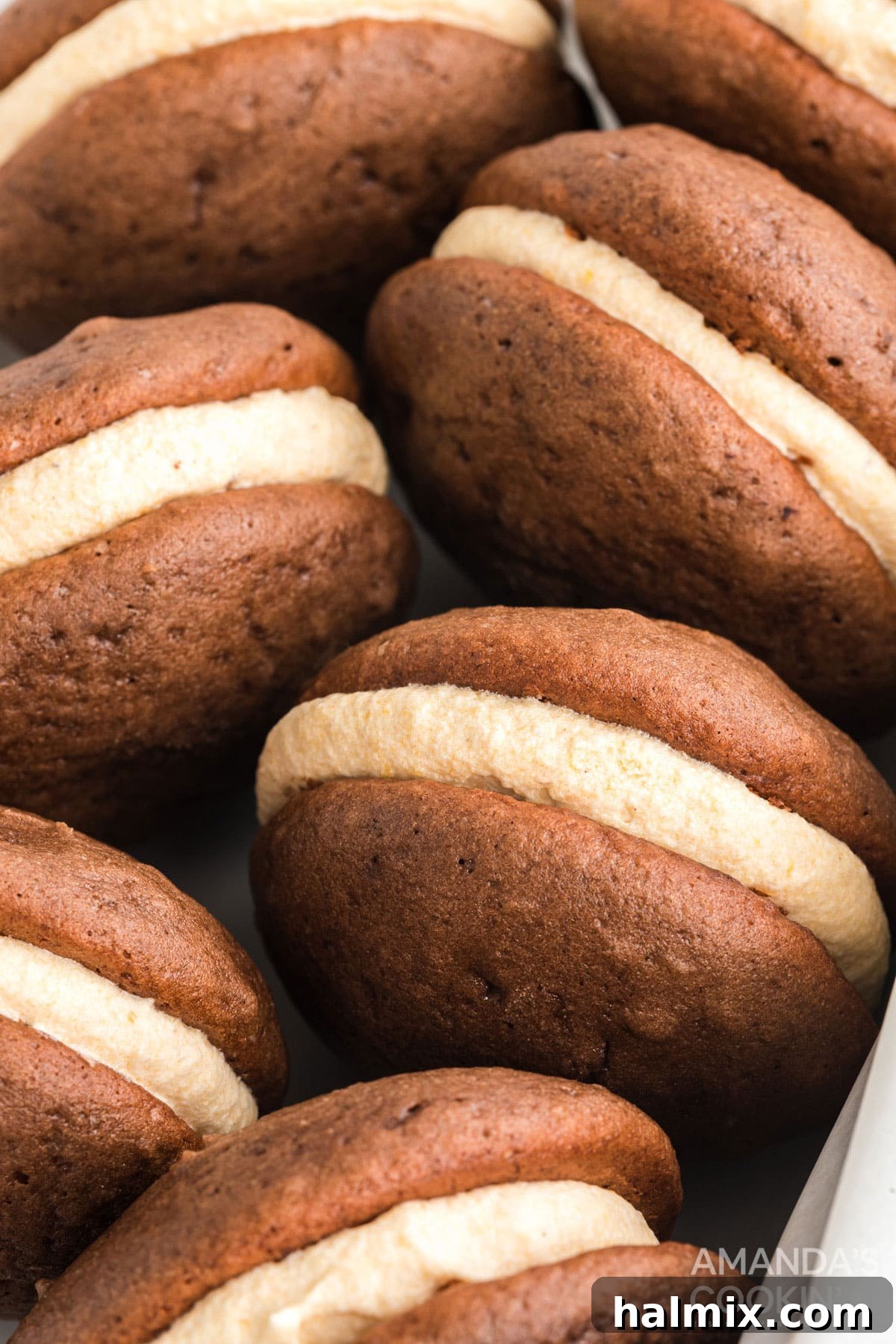 A charming wooden box filled with freshly baked mini pumpkin whoopie pies, ready to be enjoyed as a delightful fall dessert or snack.