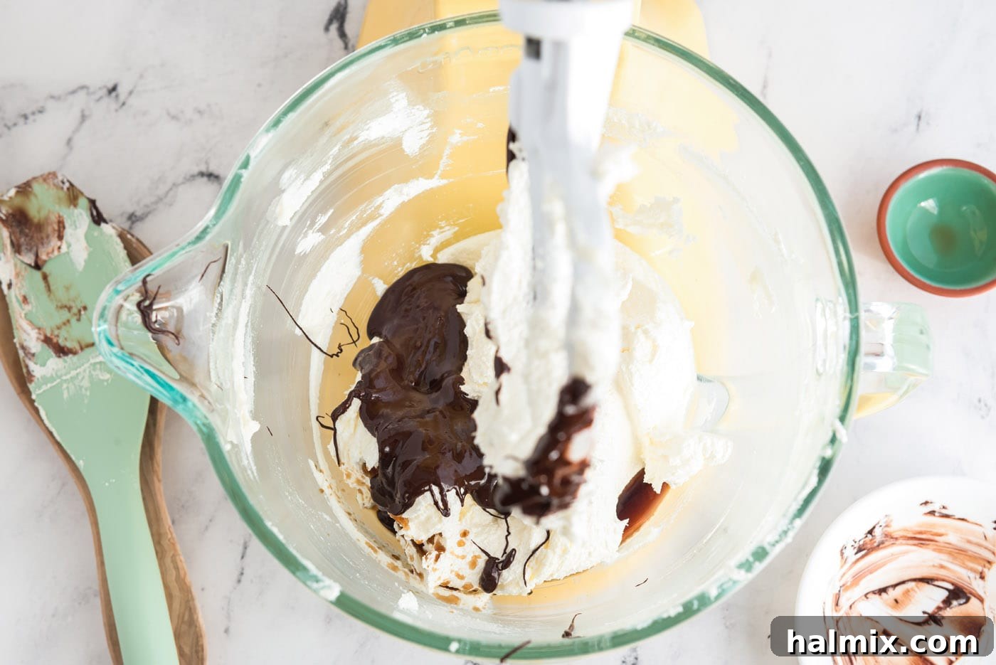 Decadent French Silk Delight 9 Cooled melted chocolate and vanilla extract being added to the creamed butter and sugar mixture in a stand mixer bowl.