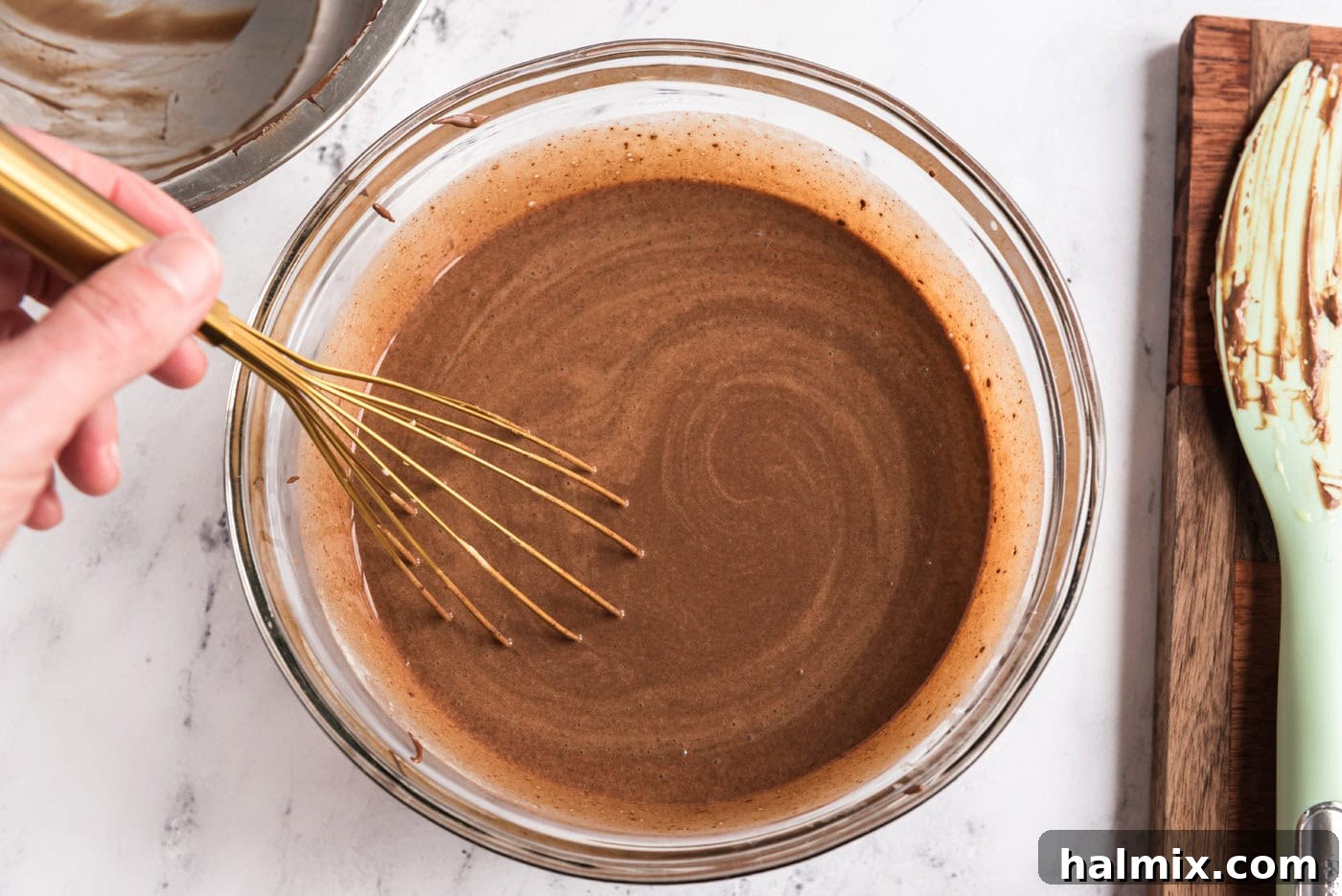 chocolate ice cream base in a bowl with a whisk
