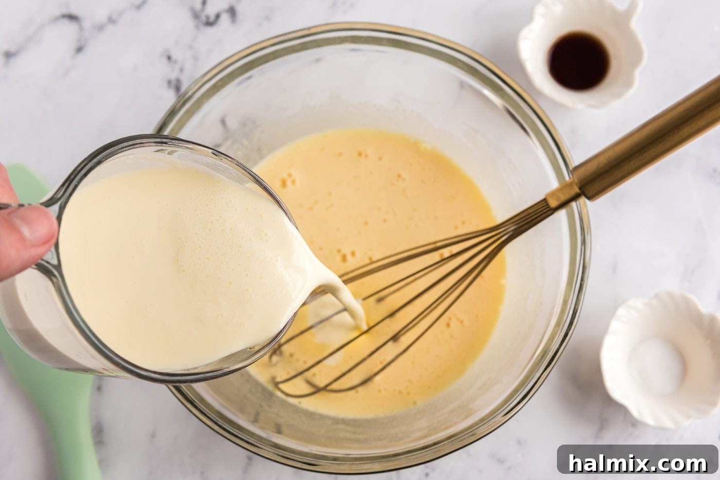 pouring heavy cream into bowl of whisked eggs and sugar mixture
