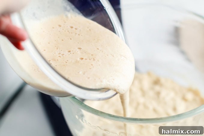 adding yeast mixture to bowl