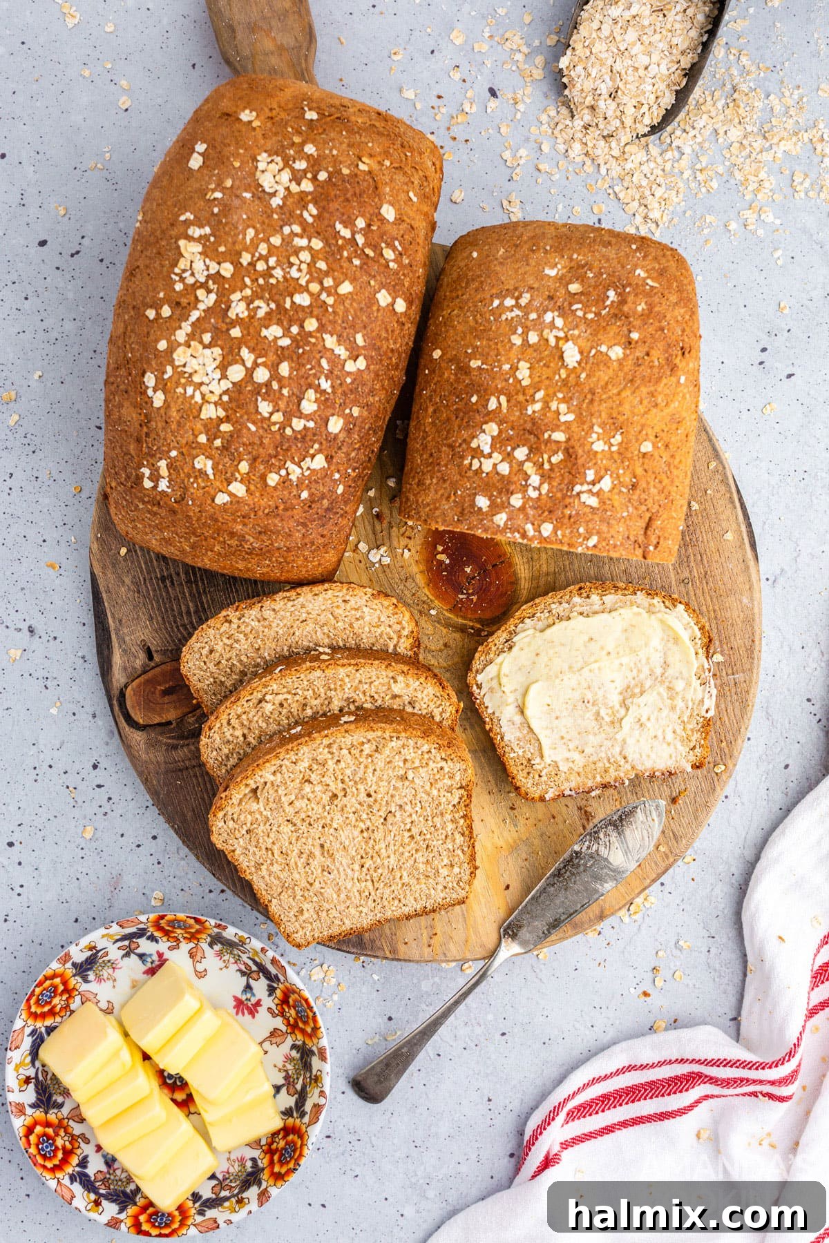 Two freshly baked loaves of golden-brown multigrain bread resting on a wooden cutting board, ready to be enjoyed.