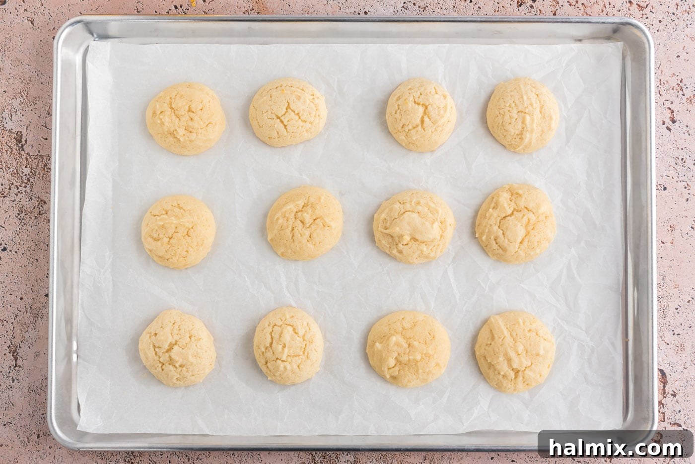 Tangy Lemon Clouds 14 Freshly baked lemon drop cookies on a baking sheet