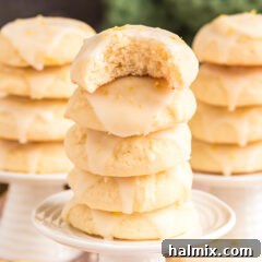 Tangy Lemon Clouds 19 Three stacks of Lemon Drop Cookies with a bite taken off the top cookie, indicating their deliciousness