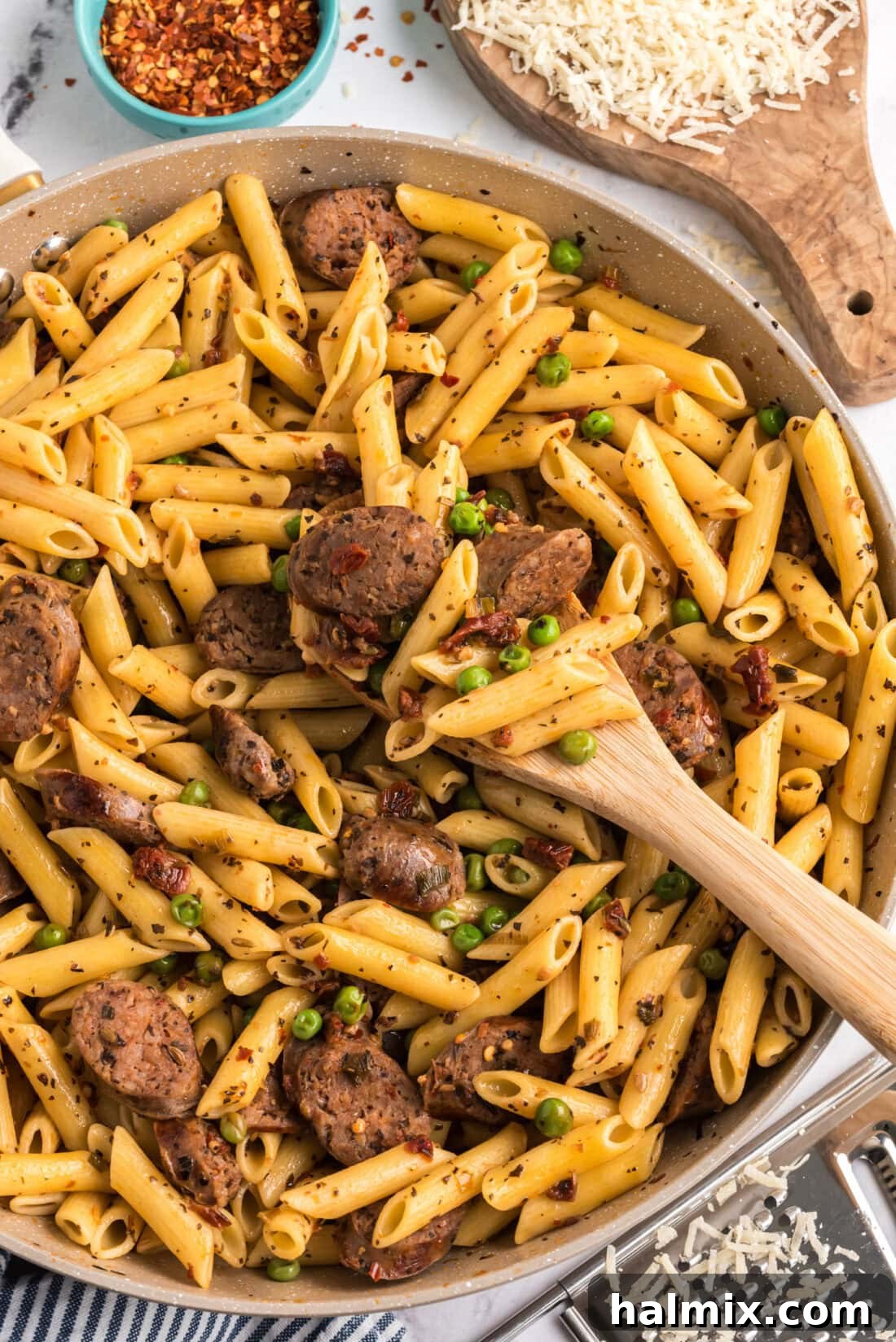 Sausage, Penne & Peas in a skillet with a spoon