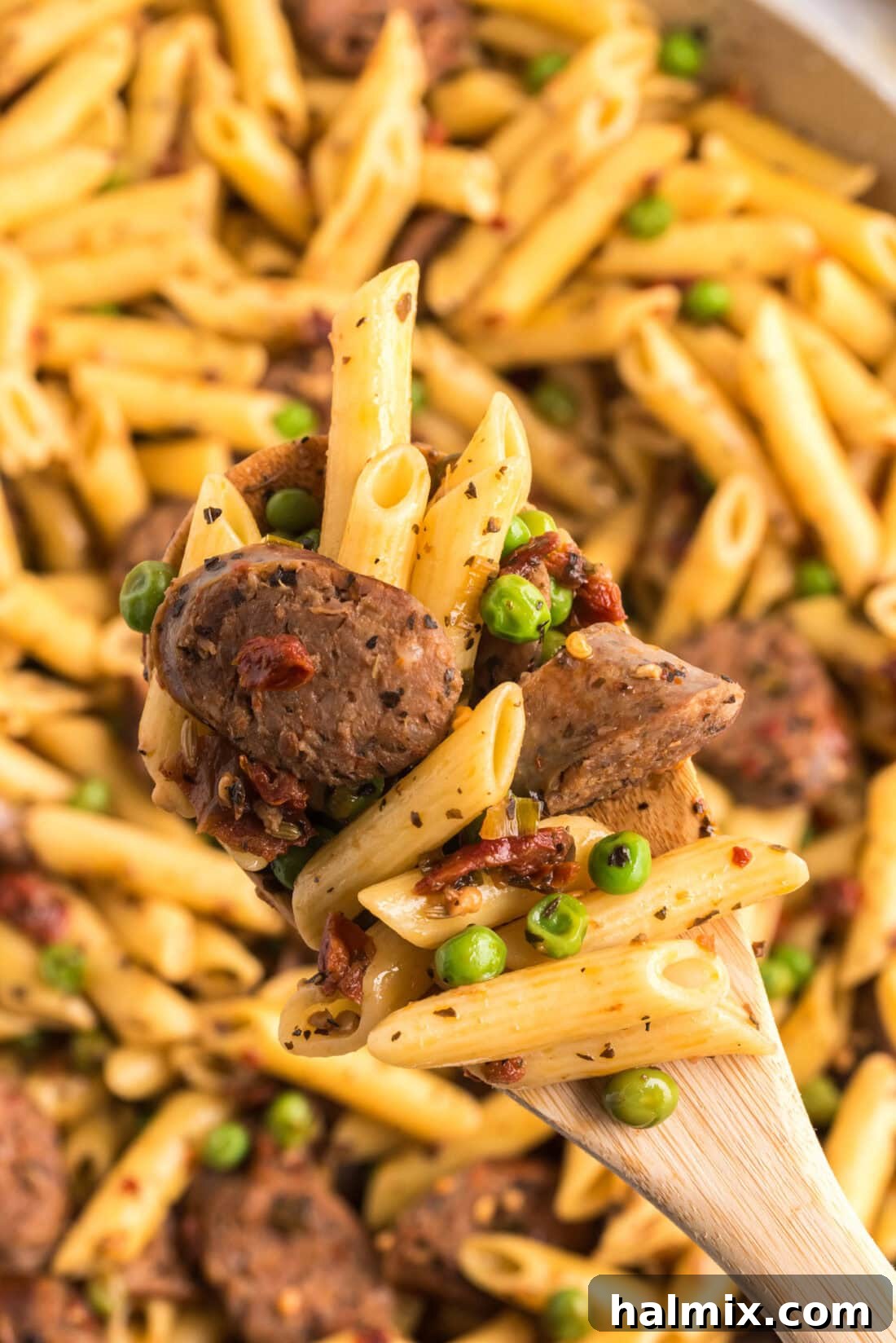 Close up photo of a spoonful of Sausage, Penne & Peas