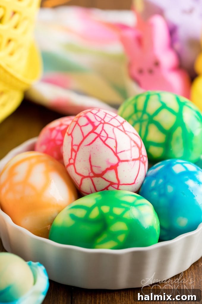 A close-up shot of beautifully cracked colored eggs, showcasing their vibrant, spiderweb-like patterns in a decorative dish, ready for Easter celebrations.