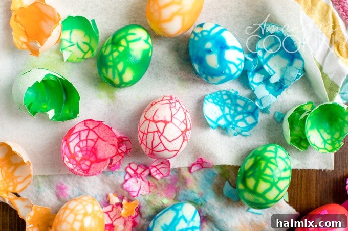 Revealing the Magic: Peeling Your Cracked Easter Eggs A close-up of a hand carefully peeling a dyed Easter egg, revealing the stunning, intricate crackled color pattern underneath the shell.
