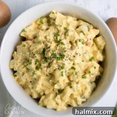 A bowl of freshly made Classic Egg Salad, garnished with chives, signifying a delicious and easy recipe.