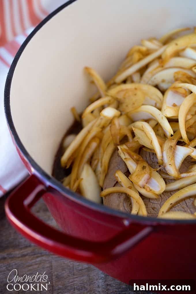 Onions layered on top of the pot roast in the Dutch oven, enhancing flavor during cooking.