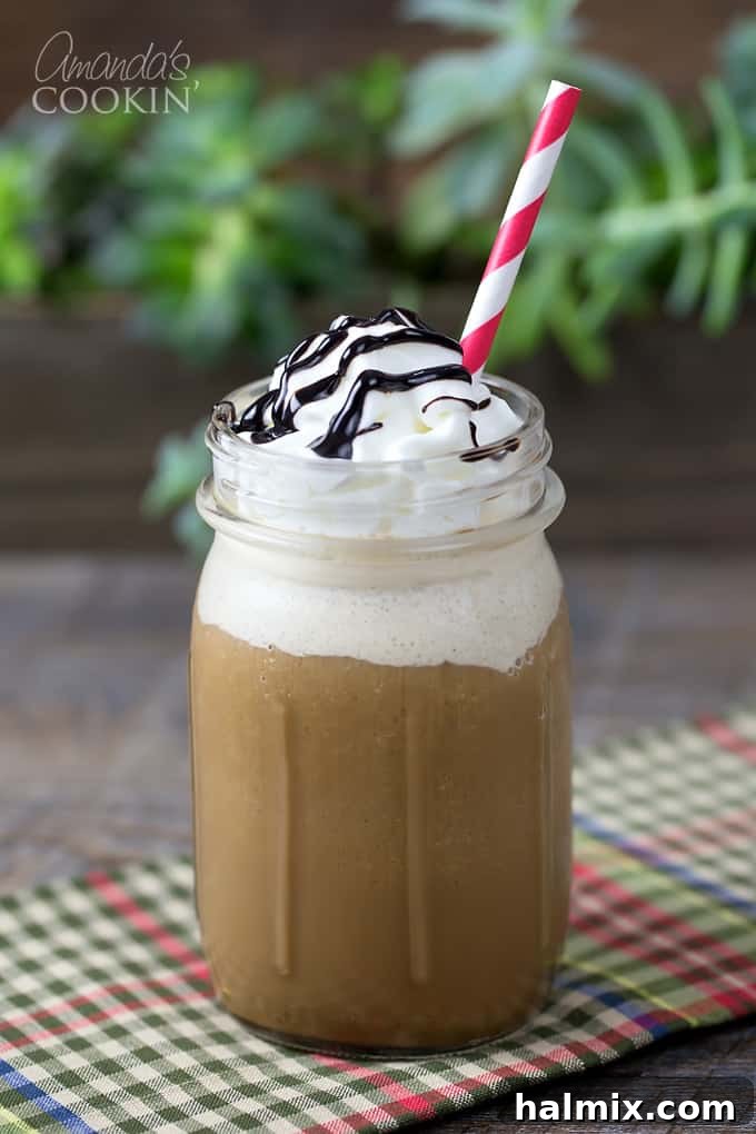 Homemade Mocha Frappe Magic 2 A mason jar filled with a mocha frappucino topped with whipped cream, chocolate sauce and a red striped straw. This homemade mocha frappuccino is a perfect Starbucks copycat.
