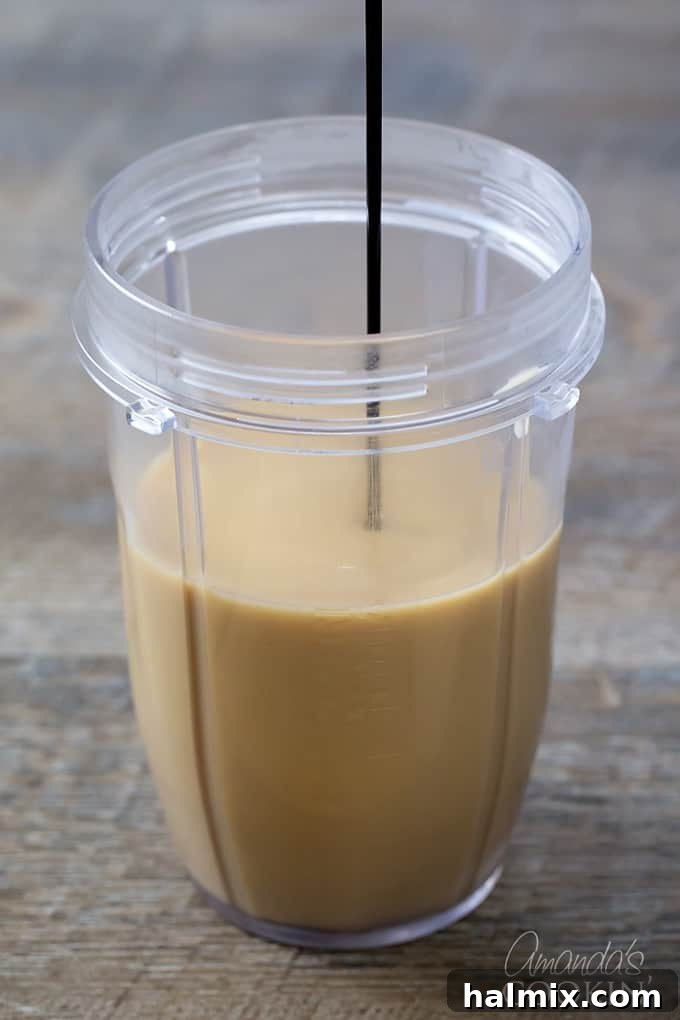 Homemade Mocha Frappe Magic 4 A blender cup with cooled brewed coffee, instant coffee, sugar, and milk, ready for the chocolate syrup to be drizzled in.